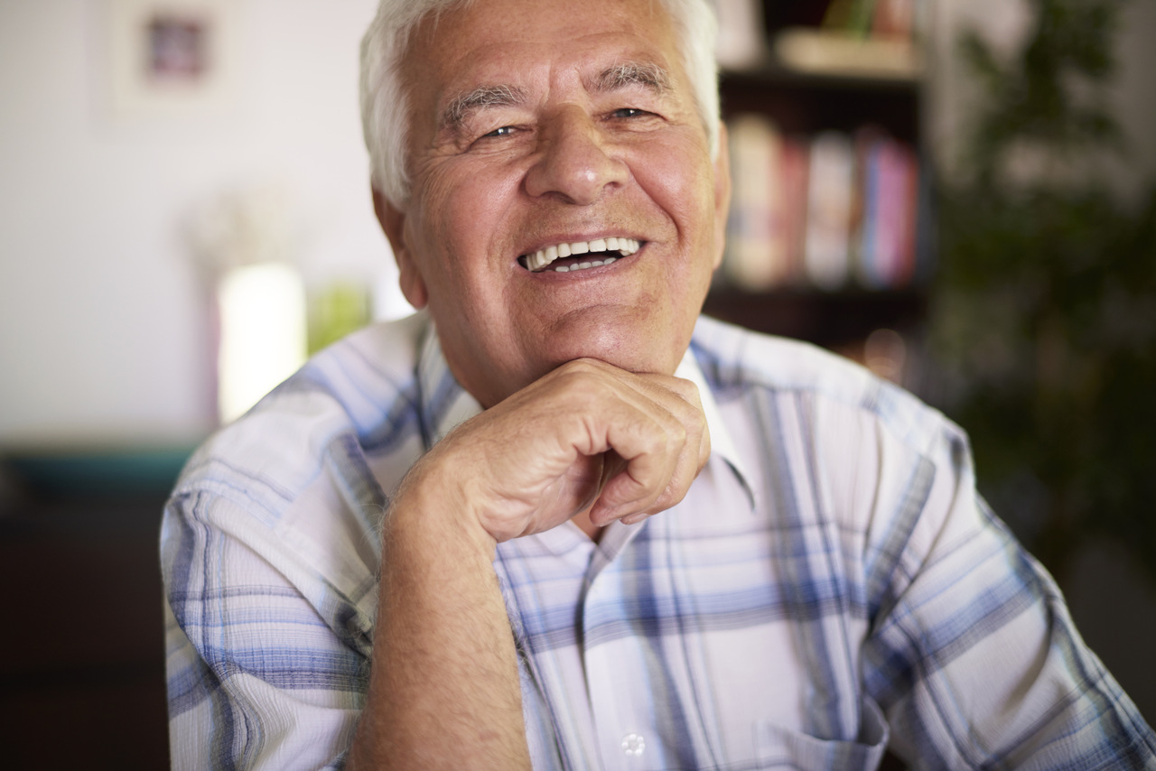 Homem de idade sorrindo para ilustrar os cuidados bucais na terceira idade.