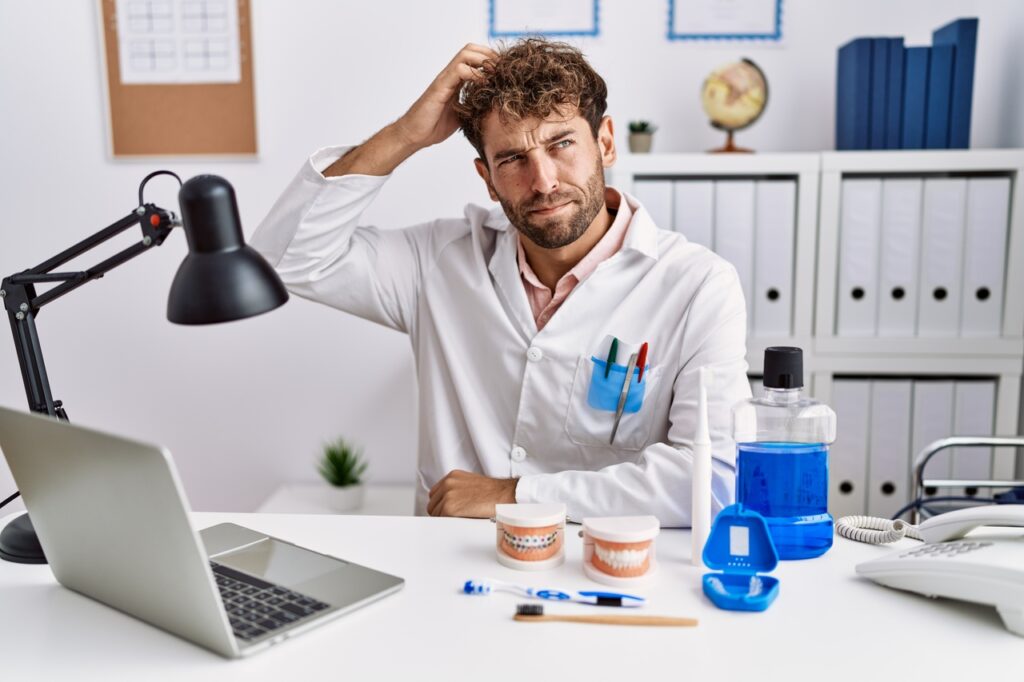 Dentista no seu consultório avaliando se lente de contato dental precisa de manutenção ou não.